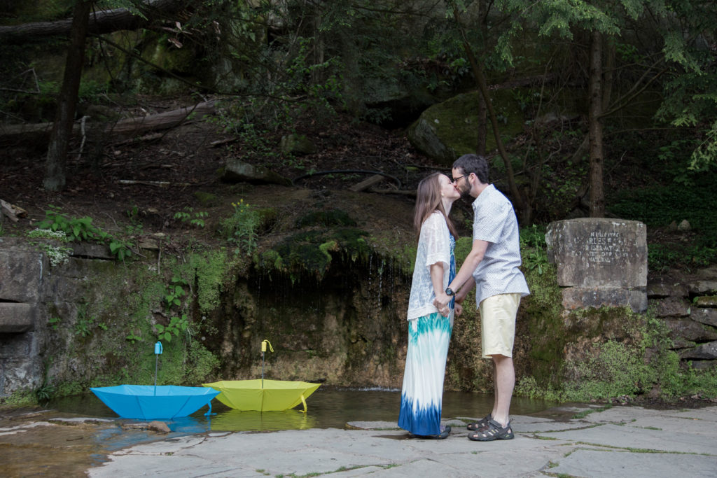 couple stand by large puddle and kiss