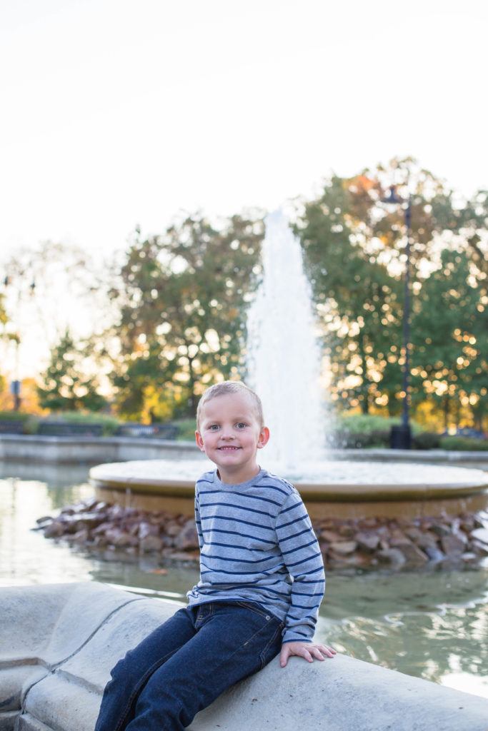 boy sits in front of fountain in highland park