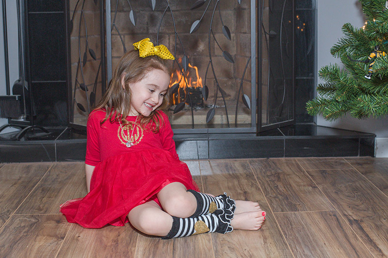 toddler sits in front of fireplace
