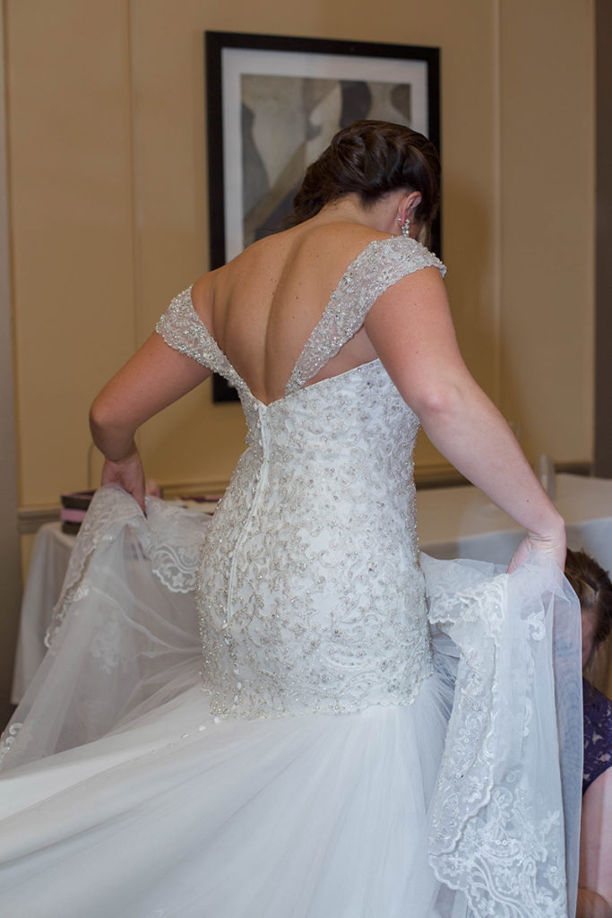 bride stands as maid of honor fixes her skirt