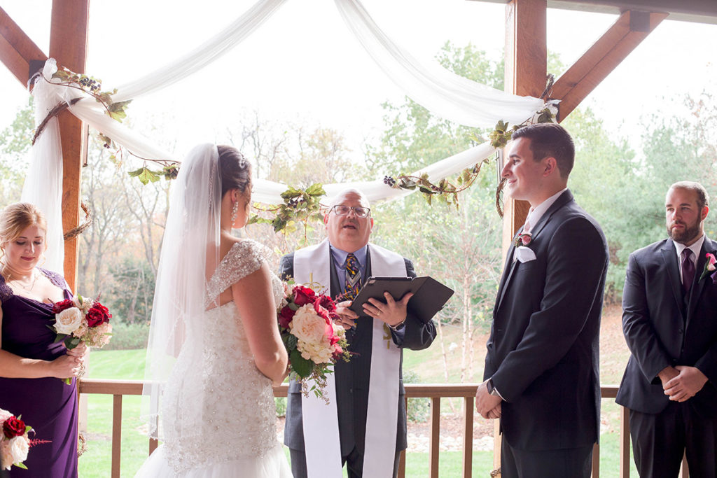 bride and groom stand in front of officiant during ceremony