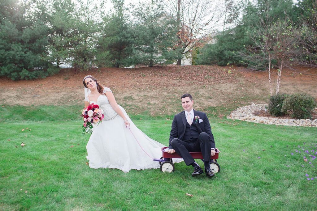 bride pretends to pull groom along in wagon