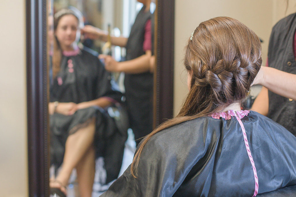 bride gets hair braided 