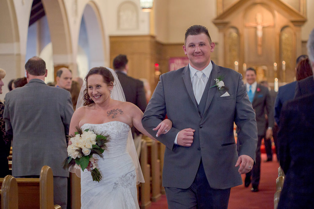 bride and groom walk up the aisle together after being married