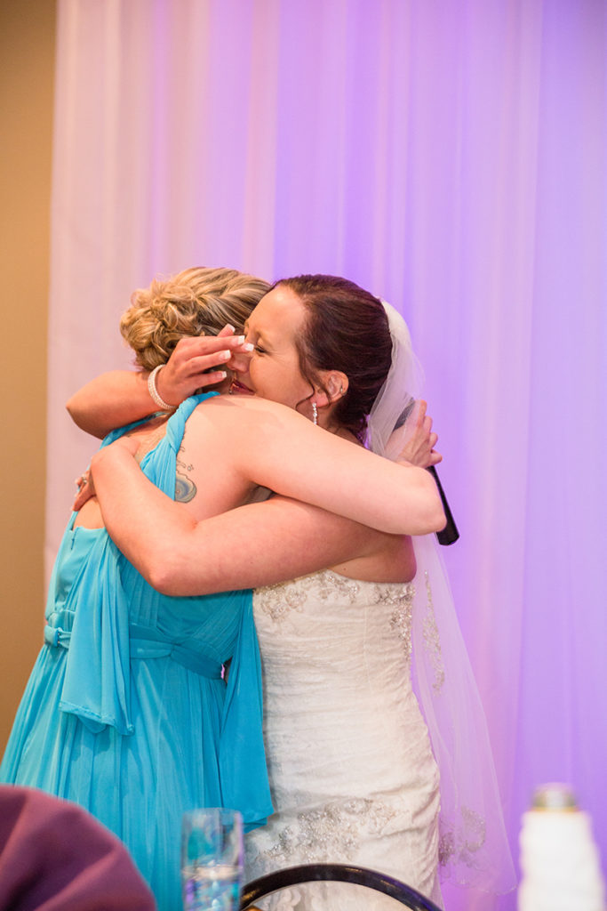 bride hugs maid of honor after speech