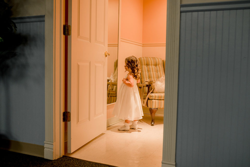 flower girl looks at her reflection in mirror