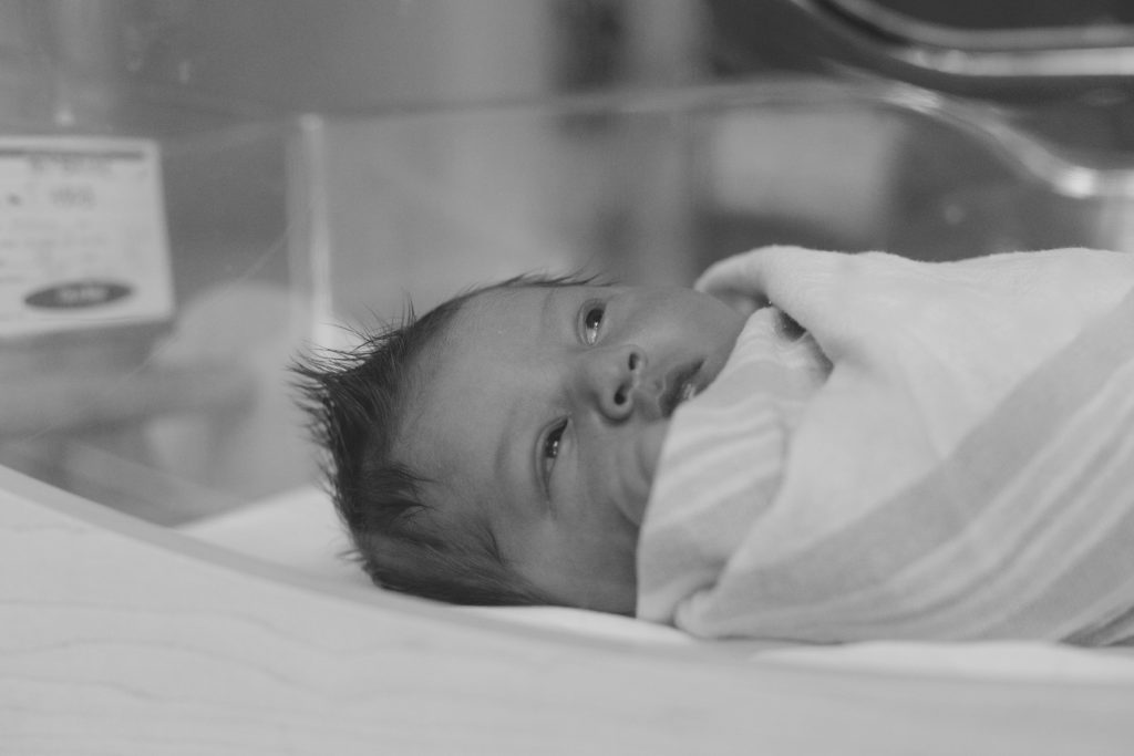 newborn boy lays in bassinet in hospital