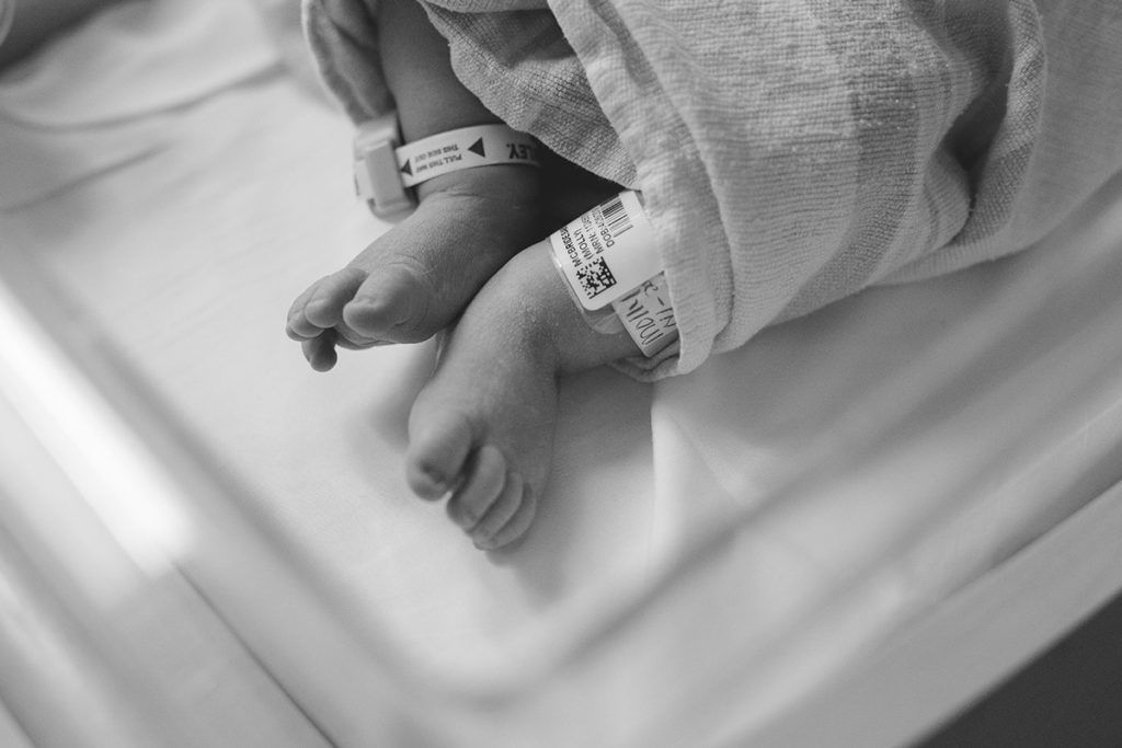 newborn baby's feet in hospital bassinet