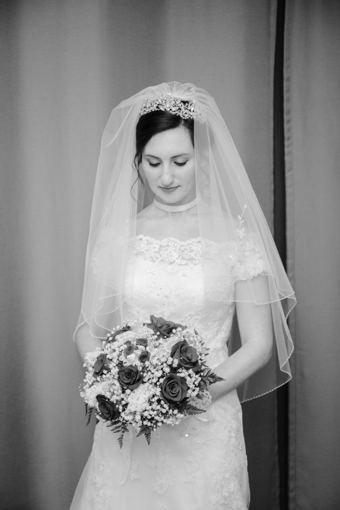 bride looks down at her bouquet before her wedding ceremony