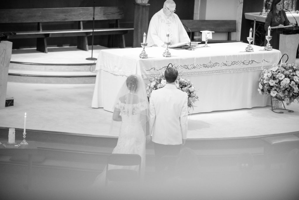 bride and groom stand at altar during wedding ceremony