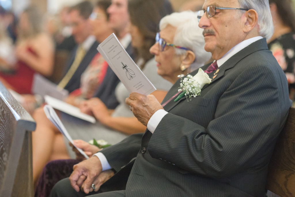 bride's grandparents hold hands during wedding ceremony
